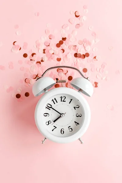 Top view white alarm clock covered golden confetti on pink background. Template feminine blog social media. Minimal style. flat lay — Stock Photo, Image