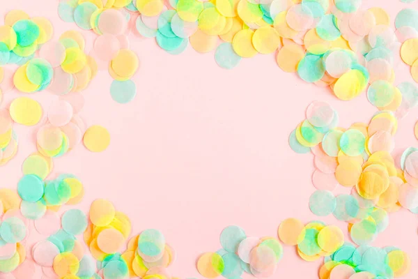Kolorowe papierowe konfetti na różowym tle. Koncepcja świętowania. Leżeć płasko. Widok z góry. — Zdjęcie stockowe