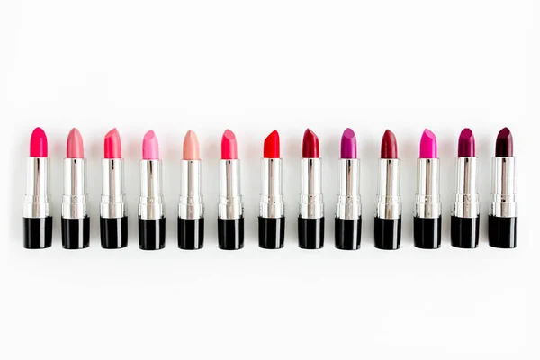 Set de lápices labiales de color sobre fondo blanco. Cosméticos decorativos profesionales, pomada de producto para publicidad. belleza, moda. plano, vista superior — Foto de Stock