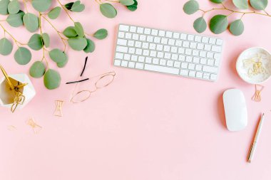 Bilgisayarlı ofis masası, yeşil yapraklı okaliptüs, dosya, altın aksesuarlar, günlük, gözlük. Dergiler, sosyal medya. Üst Manzara. Düz yatıyordu. 