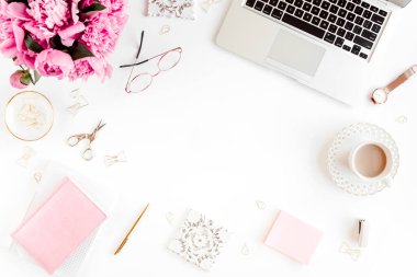 Düz uzanmış kadınların ofis masası. Dizüstü bilgisayarı olan bir kadın çalışma alanı, pembe şakayık buketi, beyaz arka planda aksesuarlar. Üst görünüm kadınsı arkaplan.