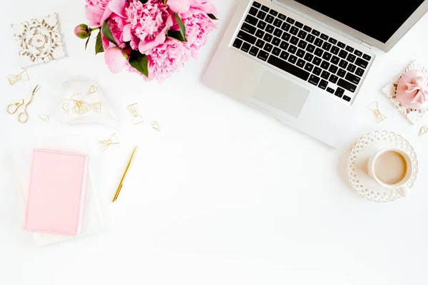 Scrivania da ufficio per donne piatte. Spazio di lavoro femminile con laptop, bouquet di peonie rosa, accessori su sfondo bianco. Vista dall'alto sfondo femminile. — Foto Stock
