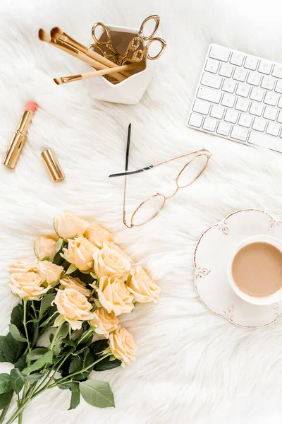 Female workspace with computer, roses flowers, golden accessories, diary, laptop, glasses on white background. Flat lay womens office desk. Top view.