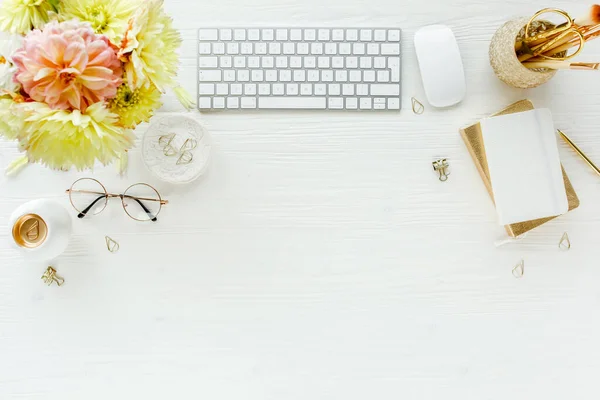 Escritorio de oficina de mujeres laicas planas. Espacio de trabajo femenino con ordenador, rosas rosadas y amarillas flores, accesorios, diario, gafas sobre fondo blanco. Vista superior —  Fotos de Stock