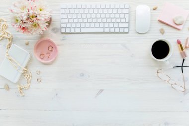 Üst kat ofis masası. Çalışma alanı, bilgisayar, kasımpatı, pano. Beyaz ahşap arka planda izole kadın aksesuarları. Düz yatıyordu