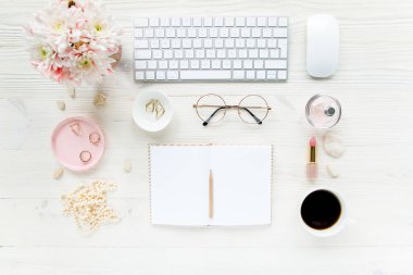 Çalışma alanı, bilgisayar, kağıt boşluğu, kasımpatı. Beyaz ahşap arka planda kadın aksesuarları. Dergiler, medya. Düz yatış, üst görünüm