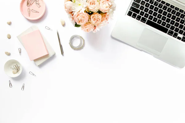 女性写字台，写字台。工作空间与笔记本电脑，玫瑰，剪贴板。白色背景的女装配饰。平铺顶视图 — 图库照片