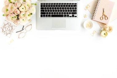 Tarz sahibi kadınların ofis masası. Laptop, bilgisayar, buket ranunculus ve güllerle çalışma alanı, beyaz arka planda pano. Düz yatıyordu. Üst görünüm.