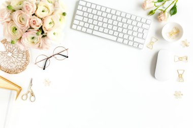 Tarz sahibi kadınların ofis masası. Bilgisayarlı çalışma alanı, buket ranunculus ve güller, beyaz arka planda pano. Düz yatıyordu. Üst görünüm.