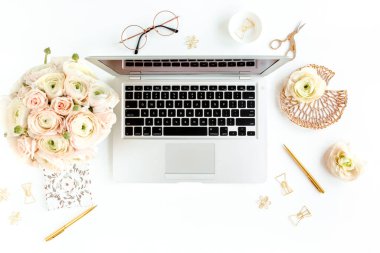 Tarz sahibi kadınların ofis masası. Laptop, bilgisayar, buket ranunculus ve güllerle çalışma alanı, beyaz arka planda pano. Düz yatıyordu. Üst görünüm.
