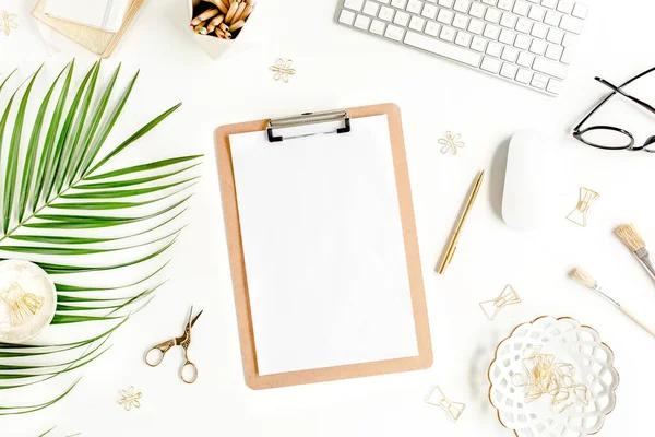 Flat lay mesa de escritório em casa. Espaço de trabalho feminino com computador, área de transferência, folhas de palma tropicais, acessórios sobre fundo branco. Vista superior. — Fotografia de Stock