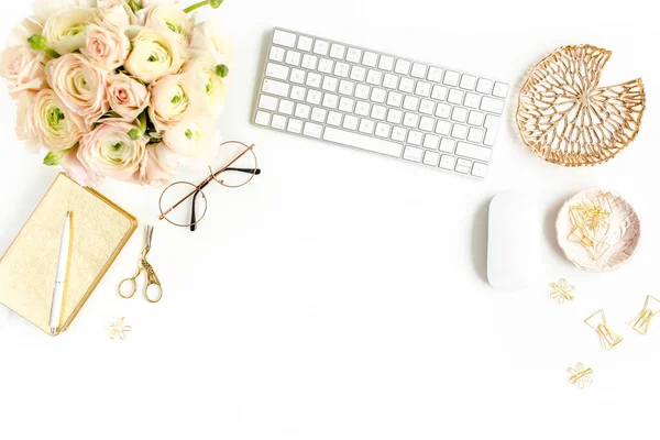 Stylized womens home office desk. Workspace with computer, bouquet ranunculus and roses, clipboard on white background. Flat lay. Top view.