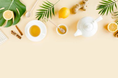 Nane, zencefil, limon, bal ve sarı arka planda diğer otlarla birlikte bitki çayı. Düz yatış, üst görünüm.