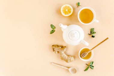 Nane, zencefil, limon, bal ve sarı arka planda diğer otlarla birlikte bitki çayı. Düz yatış, üst görünüm.