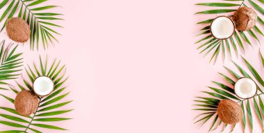 Kalıp, çerçeve kenarları, hindistan cevizi ve pembe arka planda tropik palmiye yaprakları. Tropik soyut arka plan. Düz yatış, üst görünüm.
