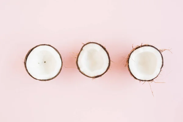 Muster mit Kokosnüssen und tropischen Palmenblättern auf rosa Hintergrund. Tropisch abstrakter Hintergrund. Flache Lage, Draufsicht. — Stockfoto