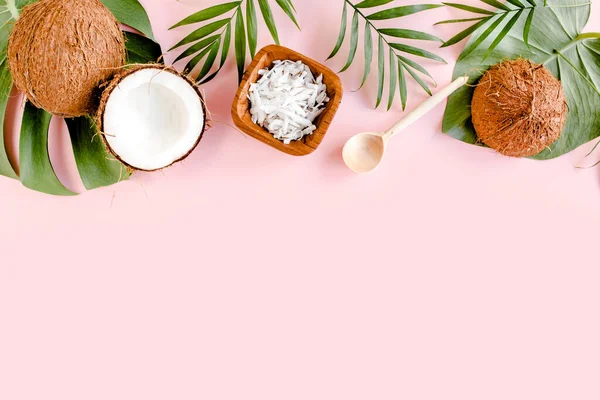 Motif avec des noix de coco et des feuilles de palmier tropical sur fond rose. Fond abstrait tropical. Couché plat, vue du dessus. — Photo
