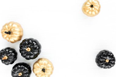 Şık Cadılar Bayramı süslemeleri. Dekoratif balkabağı siyah ve altın cadılar bayramı beyaz arka planda izole. Düz yatış, üst görünüm.