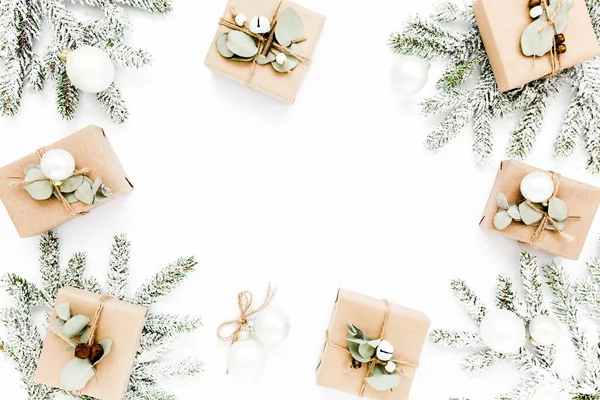 Karácsonyi keret, kézműves dobozokból készült minta és zöld ágak a hóban. Ünnepi és ünnepi koncepció. Első látásra. Lapos fektetés — Stock Fotó