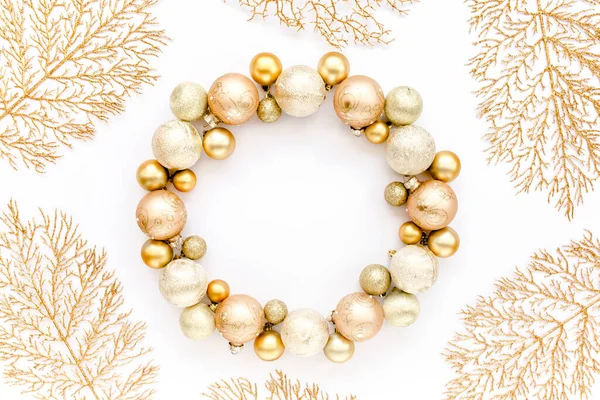 Holiday round frame, pattern made and gold glass Christmas balls, golden leaves isolated on a white background. Merry Christmas. Flat lay, top view