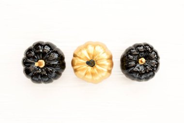 Şık Cadılar Bayramı süslemeleri. Dekoratif balkabağı siyah ve altın cadılar bayramı beyaz arka planda izole. Düz yatış, üst görünüm.