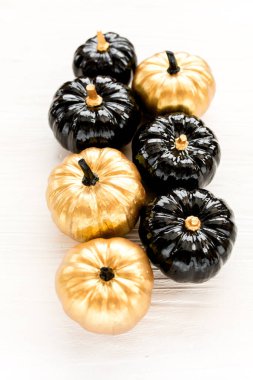 Şık Cadılar Bayramı süslemeleri. Dekoratif balkabağı siyah ve altın cadılar bayramı beyaz arka planda izole. Düz yatış, üst görünüm.