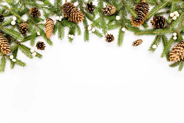 Composição de Natal com ramos de abeto, cones de pinheiro em fundo branco. Deitado plano, vista superior — Fotografia de Stock