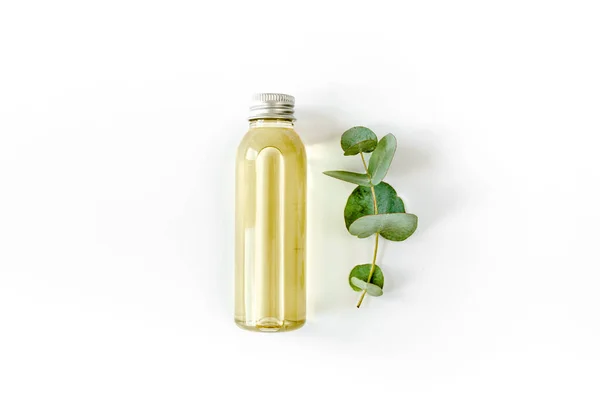 Botella de aceite esencial de eucalipto, hojas de eucalipto sobre fondo blanco. Productos cosméticos naturales y orgánicos. Piso tendido, vista superior. —  Fotos de Stock