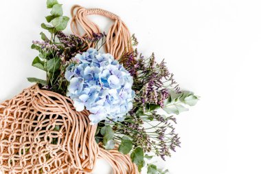 Bir ipte güzel ortanca buketi, beyaz arka planda ekolojik torba. Düz yatış, üst görünüm 