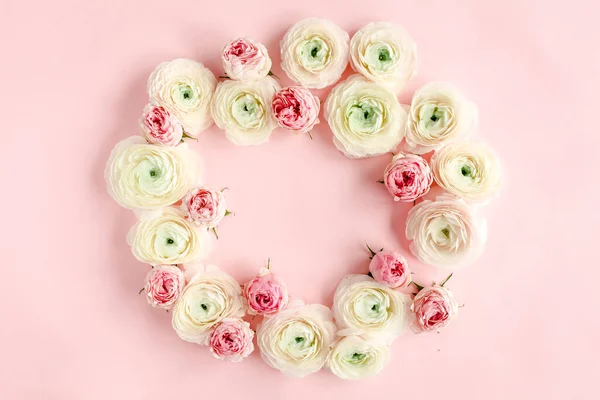 Rózsaszín ranunculusból és rózsából készült virágos háttér keret rózsaszín alapon. Lapos fektetés, felülnézet virágos háttér. — Stock Fotó