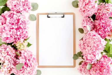 Beyaz arka planda pembe ortanca çiçeklerinden oyulmuş beyaz bir çerçeve. Çiçek konsepti. Düz yatış, üst görünüm. 