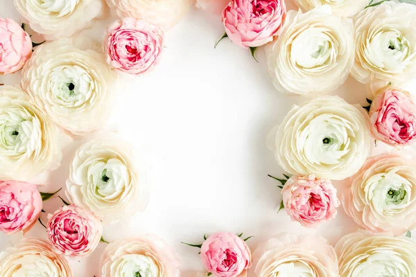 Floral frame randen gemaakt van roze ranunculus en rozen bloemknoppen op witte achtergrond. Vlakke lay, bovenaanzicht bloemenachtergrond. — Stockfoto