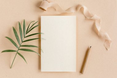 Sahte davetiye, boş tebrik kartı ve tropik palmiye yaprakları. Düz yatış, üst görünüm.