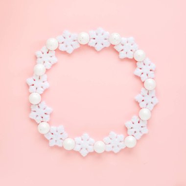 Pembe arka planda beyaz kar tanelerinden yapılmış bir tatil çerçevesi. Noel kompozisyonu, duvar kağıdı. Düz yatış, üst görünüm