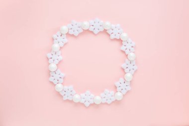 Pembe arka planda beyaz kar tanelerinden yapılmış bir tatil çerçevesi. Noel kompozisyonu, duvar kağıdı. Düz yatış, üst görünüm