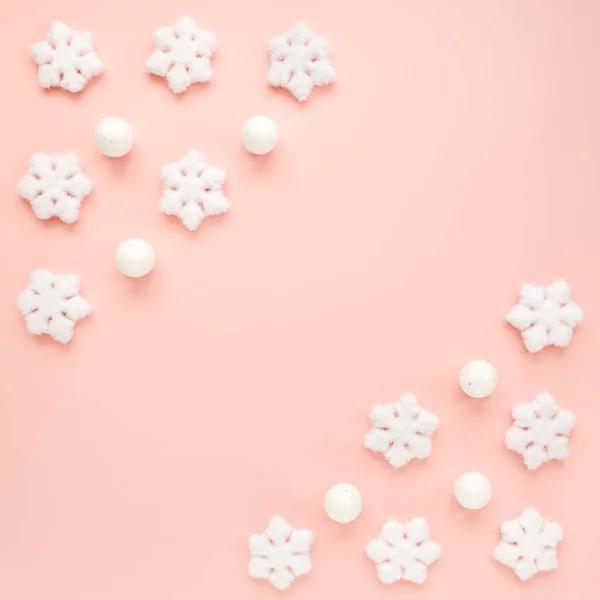 Rama świąteczna z białymi płatkami śniegu na różowym tle. Świąteczna kompozycja, tapeta. Płaskie ułożenie, widok z góry — Zdjęcie stockowe