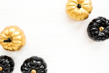 Şık Cadılar Bayramı süslemeleri. Dekoratif balkabağı siyah ve altın cadılar bayramı beyaz arka planda izole. Düz yatış, üst görünüm.