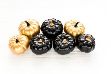 Şık Cadılar Bayramı süslemeleri. Dekoratif balkabağı siyah ve altın cadılar bayramı beyaz arka planda izole. Düz yatış, üst görünüm.