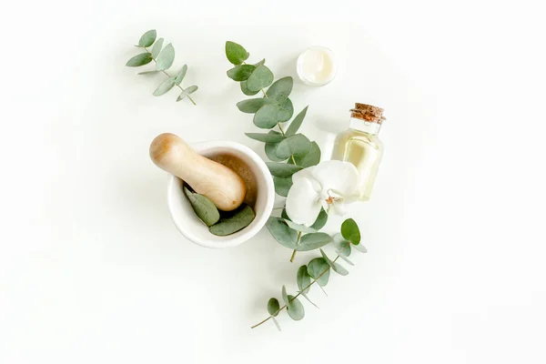 Botella de aceite esencial de eucalipto, hojas de eucalipto sobre fondo blanco. Productos cosméticos orgánicos naturales. Piso tendido, vista superior. — Foto de Stock