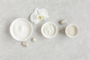 Kadın derisi ve vücut bakımı kozmetik ürünleri seti: yüz kremi, kozmetik kil, gri mermer arka planda deniz tuzu. Güzellik blogcusu, kuaför tedavisi 