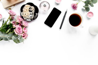 Ofis masası. Çalışma alanı boya fırçası, dizüstü bilgisayar, pembe çiçekler, beyaz arka planda telefon. Düz kompozisyon. Üst görünüm, ev ofis çalışma alanı