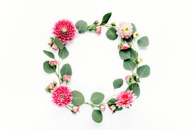 Beyaz arka planda pembe çiçek tomurcukları, dalları ve yaprakları olan yuvarlak bir çerçeve. Düz uzan, üst görünüm