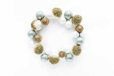 Beyaz arka planda renkli altın noel toplarından yapılmış çelenk çerçevesi. düz yatış, üst görünüm