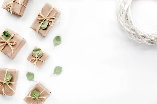 Noel oyuncakları ve el sanatları kutuları. Beyaz arka planda sanat kutuları ve yeşil dallardan oluşan yaratıcı düzenleme çerçevesi. düz yatış, üst görünüm — Stok fotoğraf