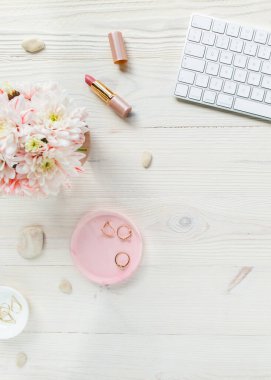 Üst kat ofis masası. Çalışma alanı, bilgisayar, kasımpatı, pano. Beyaz ahşap arka planda izole kadın aksesuarları. Düz yatıyordu