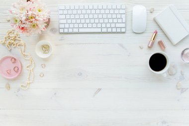 Üst kat ofis masası. Çalışma alanı, bilgisayar, kasımpatı, pano. Beyaz ahşap arka planda izole kadın aksesuarları. Düz yatıyordu