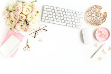 Tarz sahibi kadınların ofis masası. Bilgisayarlı çalışma alanı, buket ranunculus ve güller, beyaz arka planda pano. Düz yatıyordu. Üst görünüm.