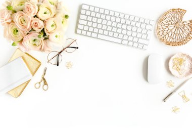 Tarz sahibi kadınların ofis masası. Bilgisayarlı çalışma alanı, buket ranunculus ve güller, beyaz arka planda pano. Düz yatıyordu. Üst görünüm.