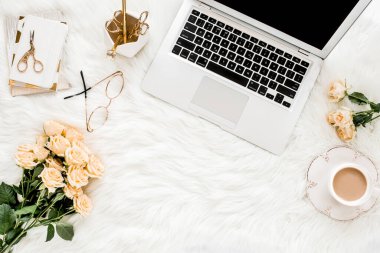 Dizüstü bilgisayarı, gülleri, altın aksesuarları, günlüğü, bilgisayarı, beyaz arka planda gözlüğü olan kadın çalışma alanı. Düz uzanmış kadınların ofis masası. Üst görünüm