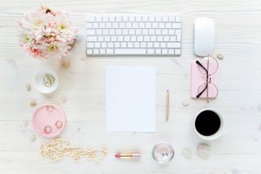 Çalışma alanı, bilgisayar, kağıt boşluğu, kasımpatı. Beyaz ahşap arka planda kadın aksesuarları. Dergiler, medya. Düz yatış, üst görünüm